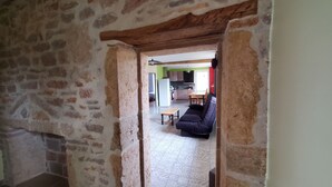 A rustic interior with exposed brick walls, a wooden ceiling, and a dining area with a table and chairs. - The fountains (Laives)
