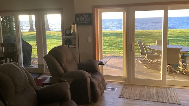 A living room with a large sliding glass door leading to an outdoor patio with a view of the lake. - Spacious 4BD 3Bth townhouse on the peninsula! (Onamia)