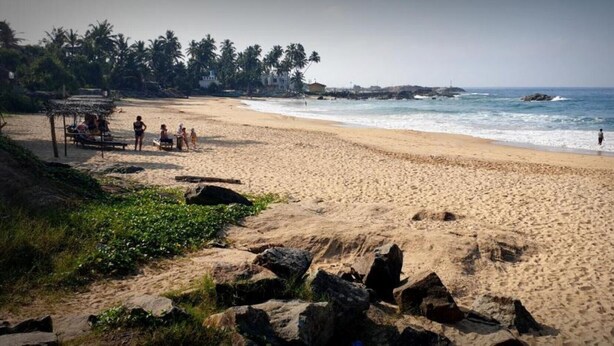 A beach with a thatched structure and people near the water. - Beach villa KANDU near Hikkaduwa (Kumarakanda Dodanduwa)