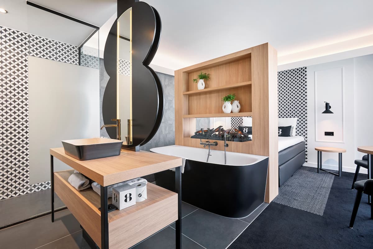 A modern bathroom with a freestanding sink, a bathtub, and a wooden vanity.