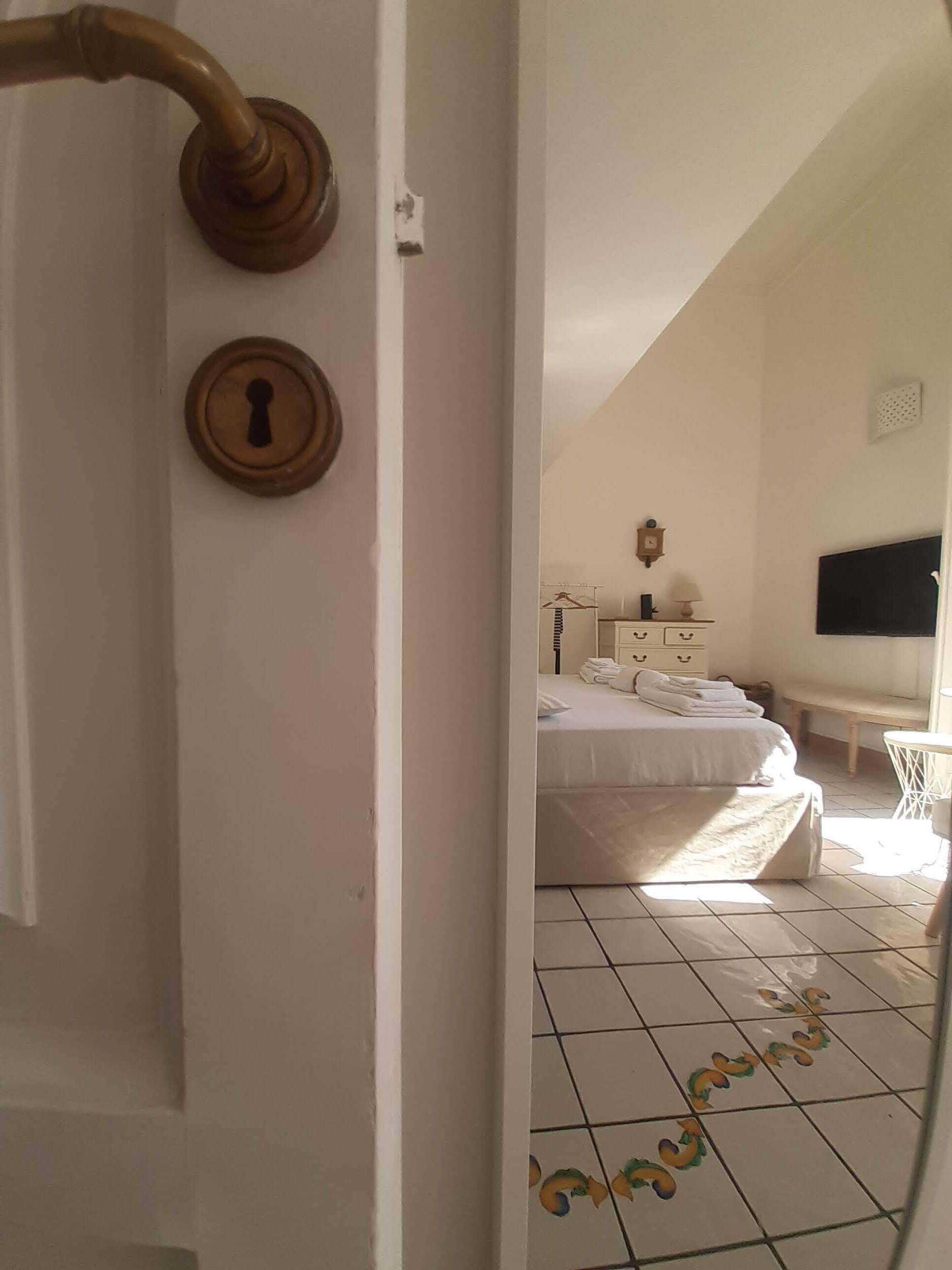 Ein Schlafzimmer mit einem Bett, einem Fernseher und einer Wanduhr.