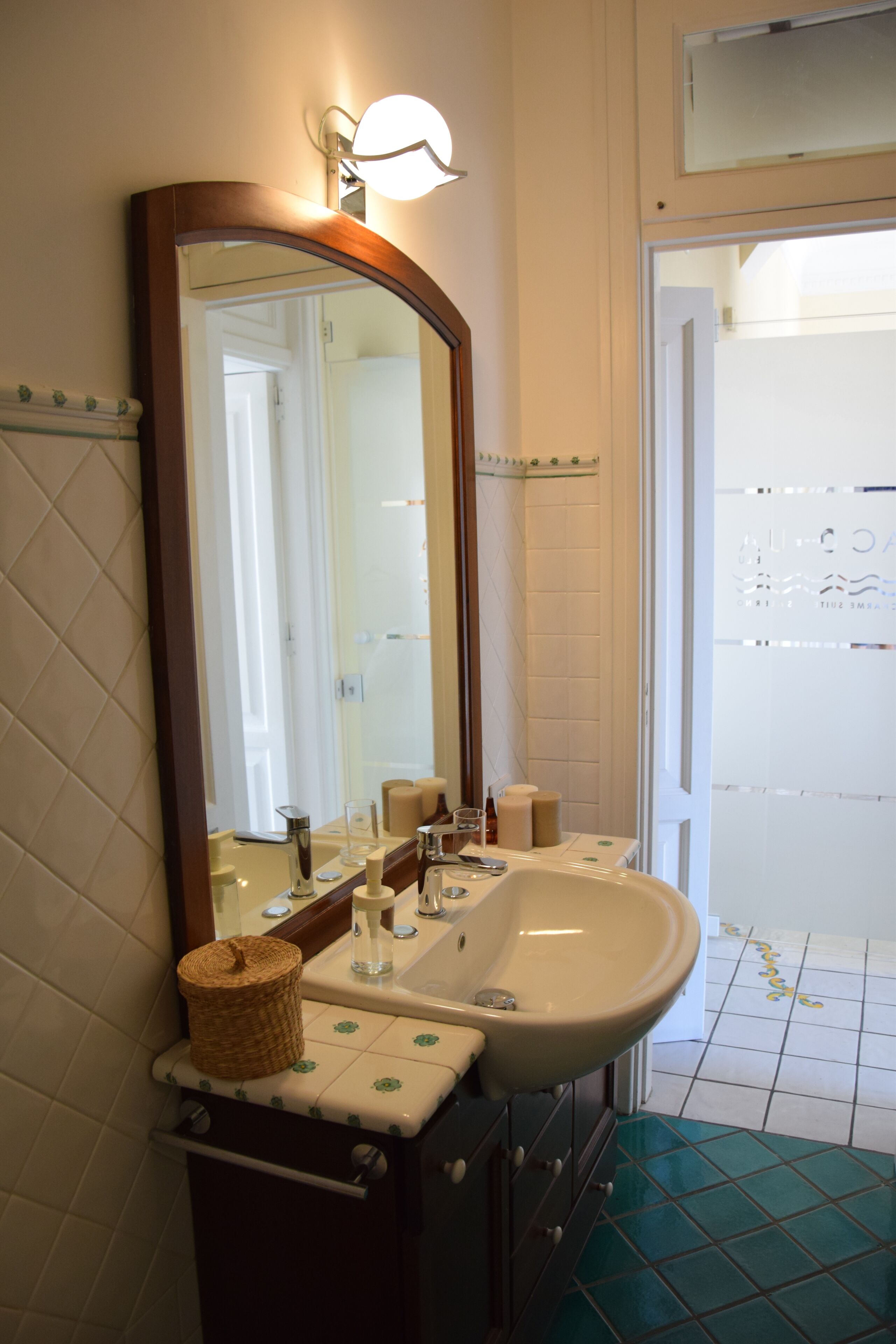 A bathroom with a large mirror, a sink, and a shower area.
