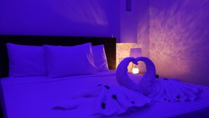 A hotel room with a bed, pillows, a heart-shaped towel arrangement, and a lamp. - New Midtown Hotel (Cairo)