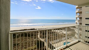 Un balcon avec vue sur la plage et l’océan.