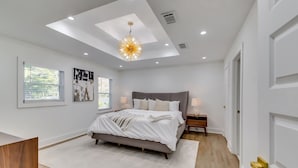 Quarto moderno com uma cama grande, um claraboia e um candeeiro único.