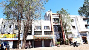 Um edifício com vários andares e fachada comercial no andar térreo.