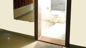 Porta de entrada para um banheiro com vaso sanitário e cortina de chuveiro.