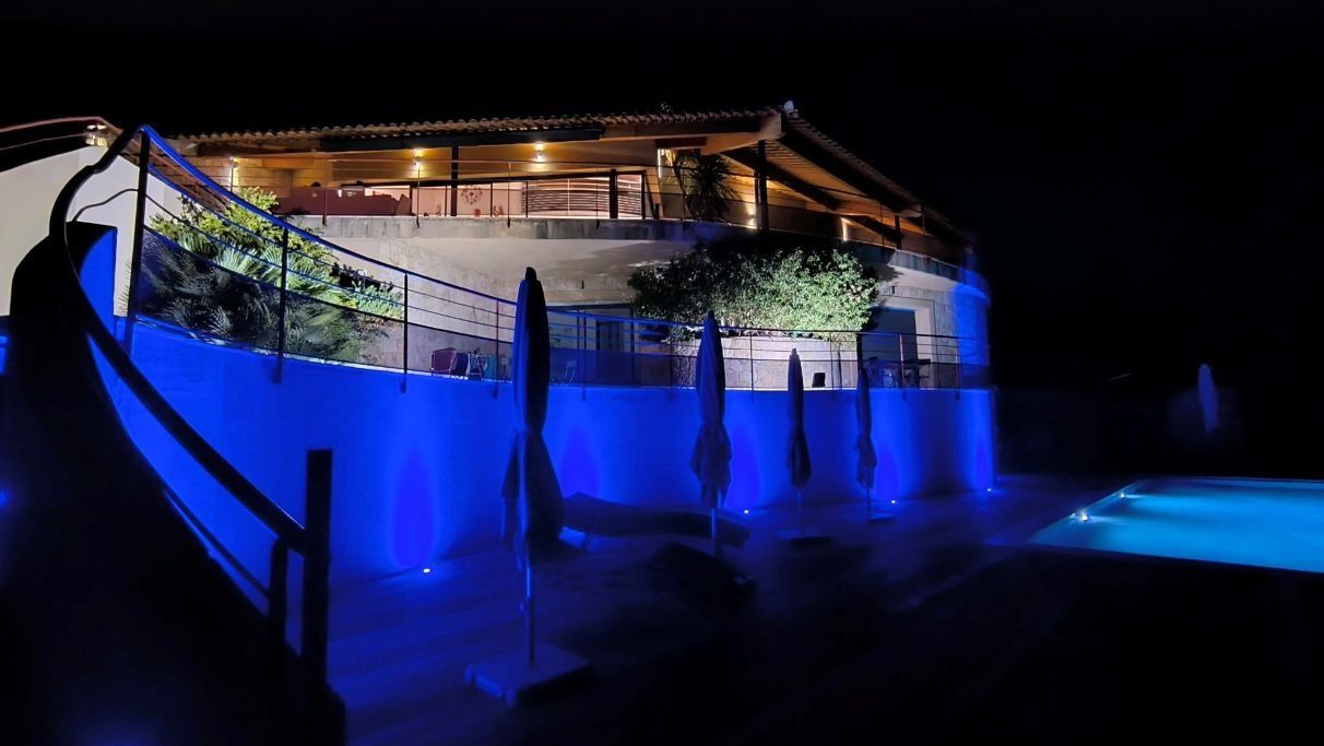A building with a swimming pool, stairs, and a balcony.