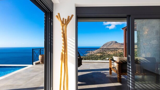 A modern villa with a glass door leading to a terrace with a pool and a view of the sea. - Villa Sea-Esta in Sellia with spectacular Sea view and pool, Adults Only (Rethymno)