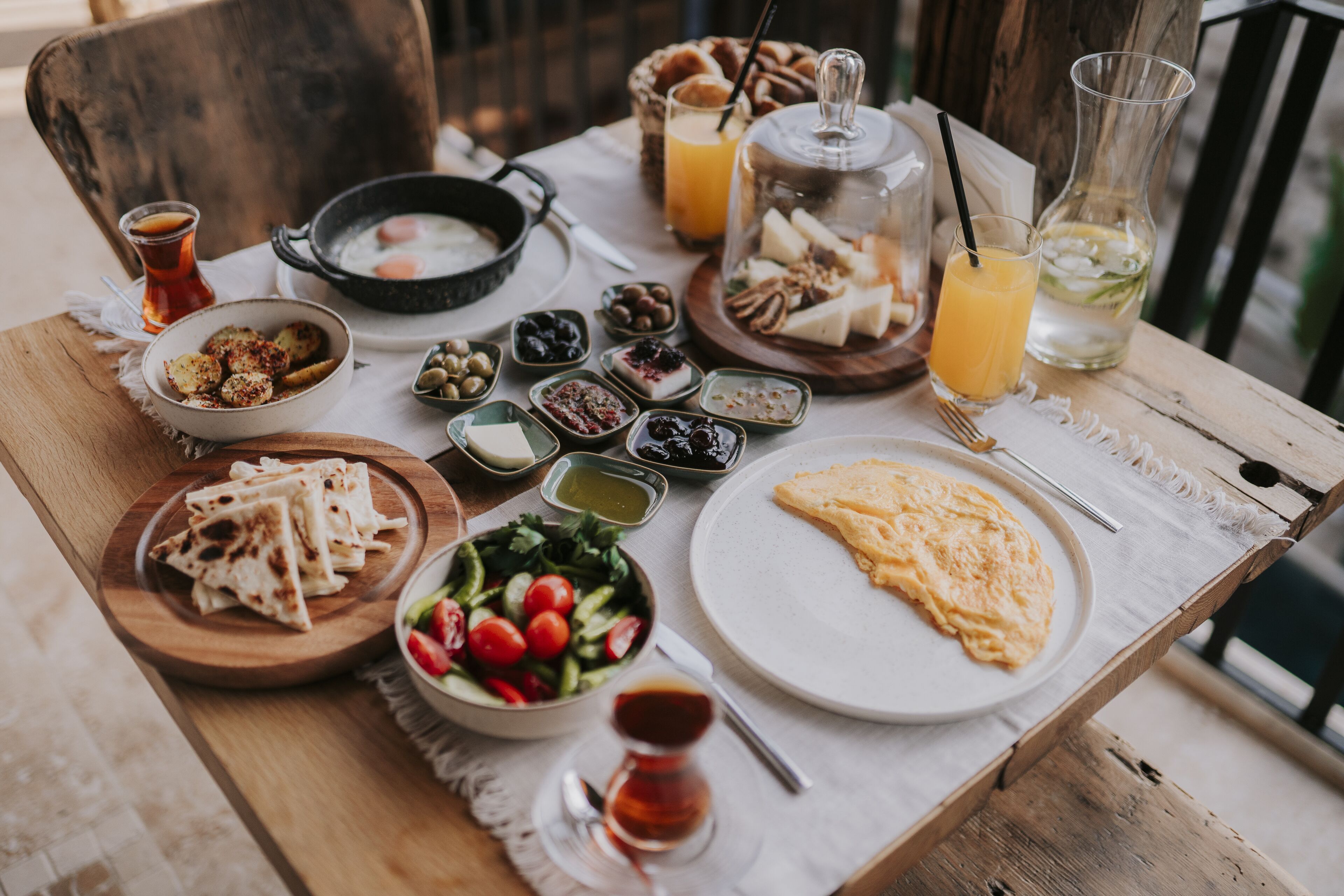 A table set with various breakfast items including eggs, bread, and a salad.