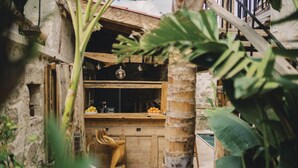 A rustic kitchen with a wooden counter, a wooden chair, and a small pool. - Suare Alaçatı (Cesme)