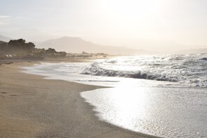 A beach with waves, a clear sky, and distant mountains. - LOTUS villa in PRINES, private pool, near beaches, restaurants, Rethymno. (Prines, Rethymno)