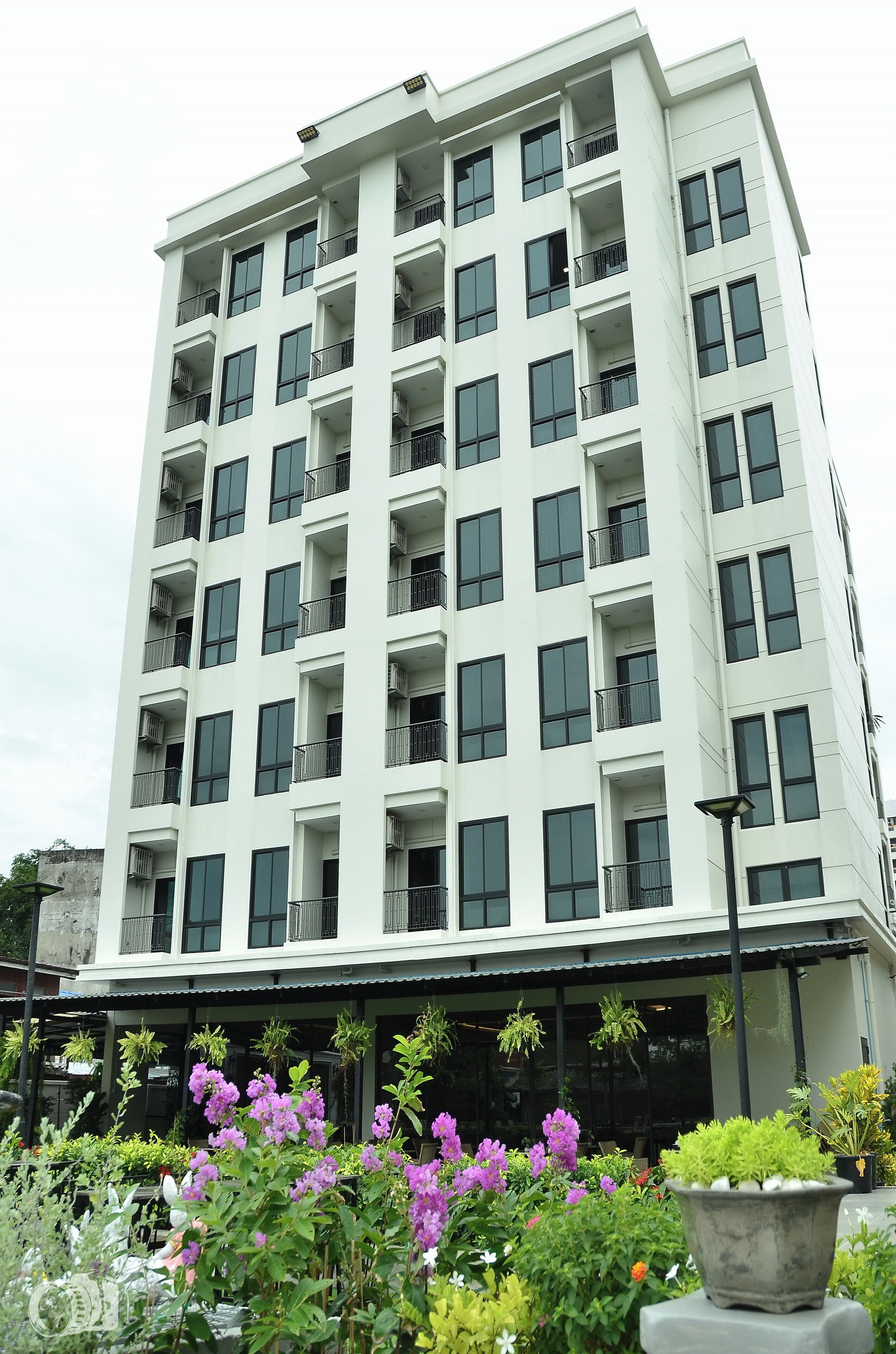 A multi-story building with balconies and large windows.