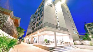 A multi-story hotel with a modern design, featuring a prominent entrance with steps and a covered area. - NORN Rimklong Bangkok Hotel (Bangkok)