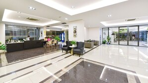 A modern lobby with a reception desk, seating area, and large windows. - NORN Rimklong Bangkok Hotel (Bangkok)