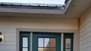 A teal front door with a welcome sign, a small porch area, and a concrete step leading up to the door. - Private home on 40 acres surrounded by wide open space. (Vernon)