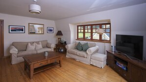 A living room with two sofas, a coffee table, a TV, and a window with a view. - Ivy Cottage, Balnaguard Detached cottage with off street parking. (Balnaguard)