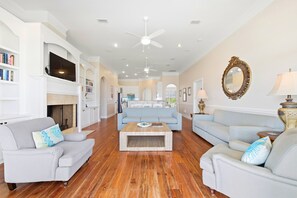 A spacious living room with a fireplace, two sofas, a coffee table, and a television.