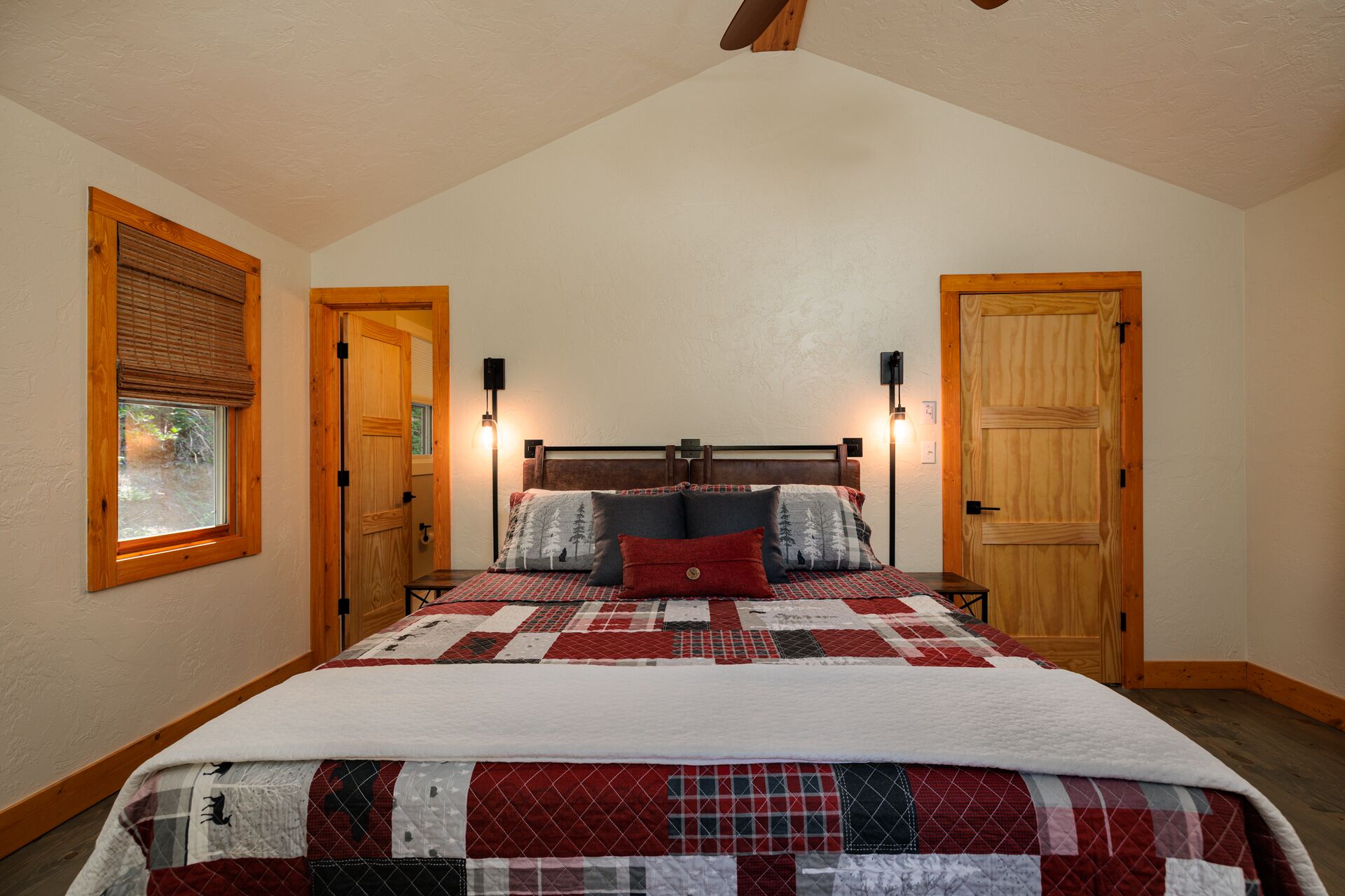 Une chambre à coucher avec un grand lit, deux lampes de chevet et une fenêtre équipée de stores.