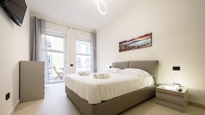 A bedroom with a bed, bedside table, and a painting on the wall.