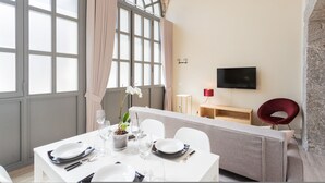 A dining area with a table set for four, a potted plant, and a television on the wall. - Romantic Escape in the 400s (Como)