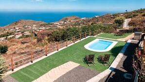 A pool with a view of the ocean, a fenced area, and a chair. - Casa Celeste, swimming pool with panoramic views in the east of La Palma (Villa de Mazo)