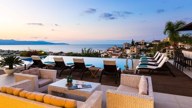 A rooftop pool area with lounge chairs and a view of the sea and cityscape. - Lux Villa 600mt to beach★Gym & Basketball ★Heated pool★100 mt to Taverna (Platanias)