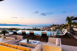 A rooftop pool area with lounge chairs and a view of the sea and cityscape. - Lux Villa 600mt to beach★Gym & Basketball ★Heated pool★100 mt to Taverna (Platanias)