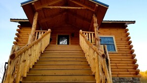 Een houten chalet met een trap naar een terras.