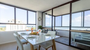 Un comedor con mesa, sillas y vista al océano.
