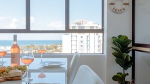 Una mesa de comedor con platos, vasos y una botella, una planta en maceta y un letrero que dice 'Kings Beach'.