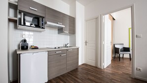 Une cuisine moderne équipée d’un four à micro-ondes encastré, d’un lave-vaisselle et de meubles de rangement en bois.