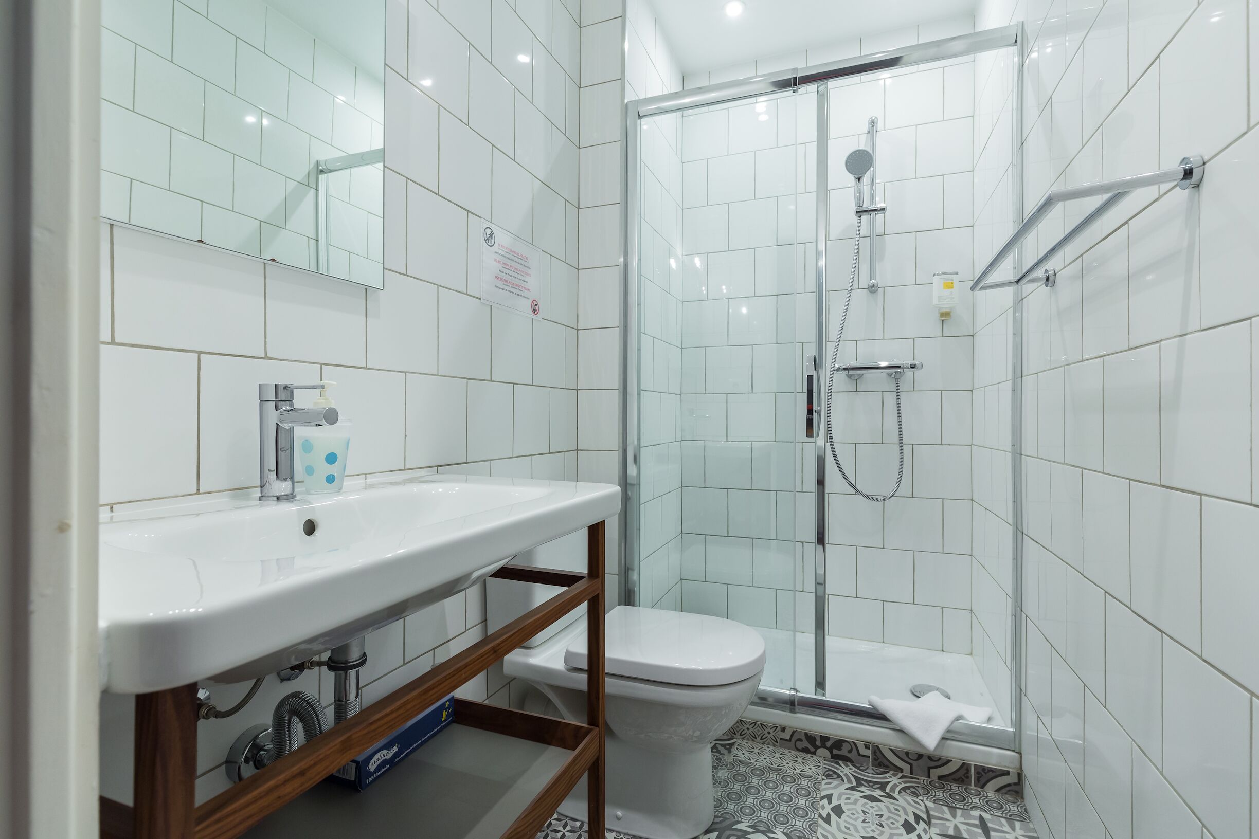 Une salle de bain moderne avec un lavabo blanc, des toilettes et une douche à parois de verre.