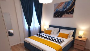 Ein modernes Schlafzimmer mit einem Bett, Nachttischen, einem Spiegel und einem Bild an der Wand.