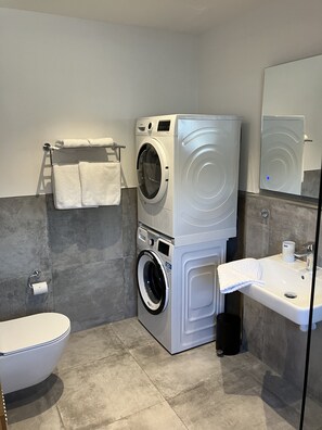 Een haardroger, handdoeken, zeep, toiletpapier