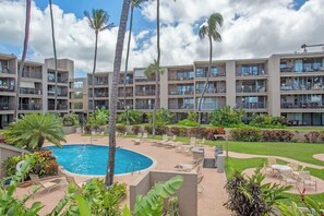Un hotel con varios pisos, piscina y zonas de estar al aire libre.
