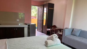 Ein Schlafzimmer mit einem Bett, einem Schreibtisch, einem Stuhl und einem Schlafsofa.