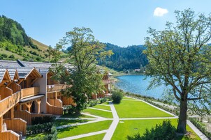 Uma cabana de madeira com vista para um lago e colinas.