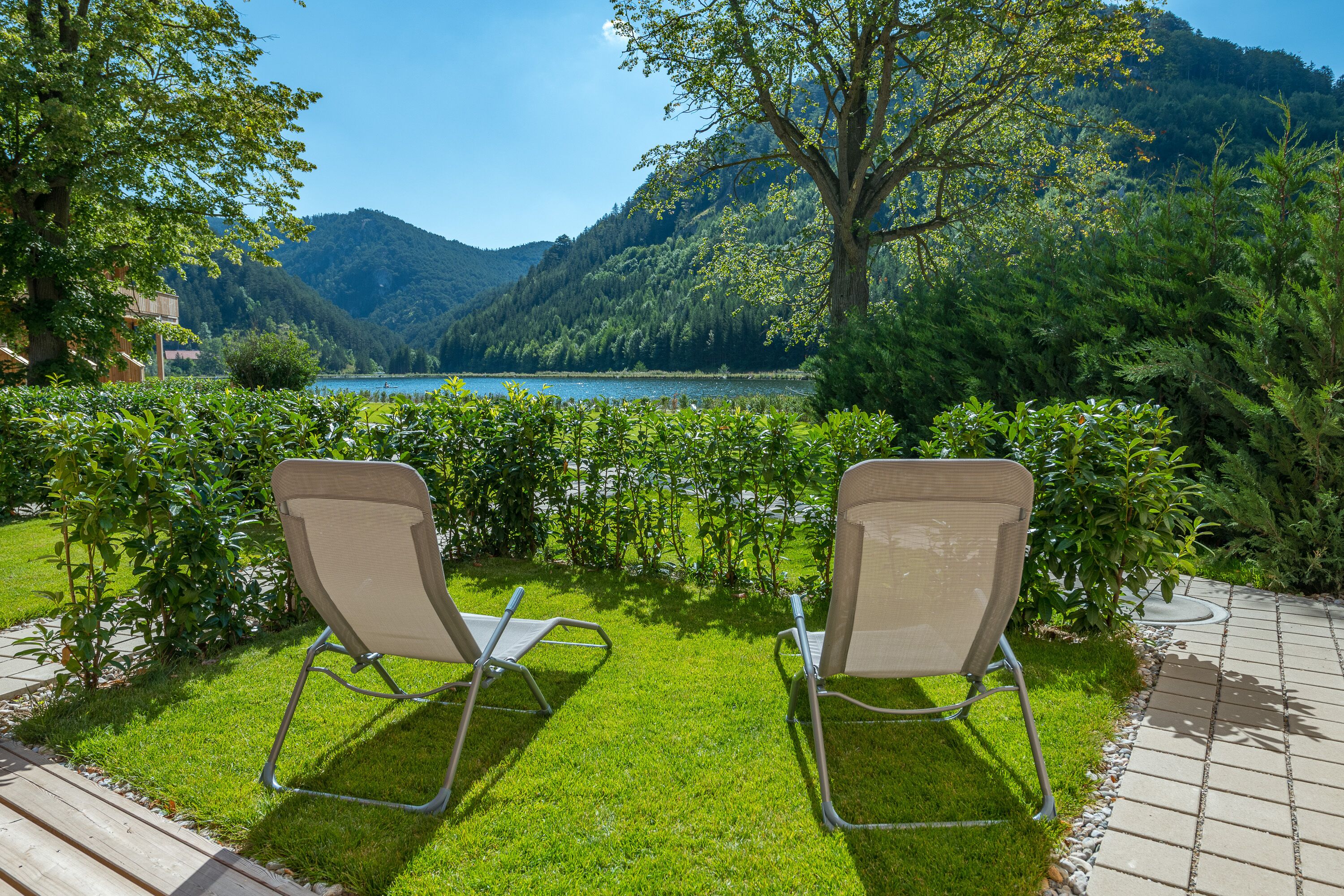 Two chairs facing a lake with mountains in the background.