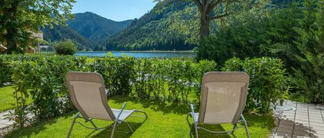 Two chairs facing a lake with mountains in the background.