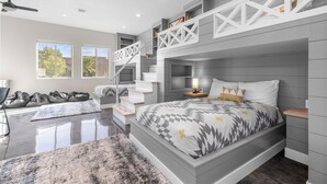 Un dormitorio moderno con literas, una escalera y una zona de lectura.