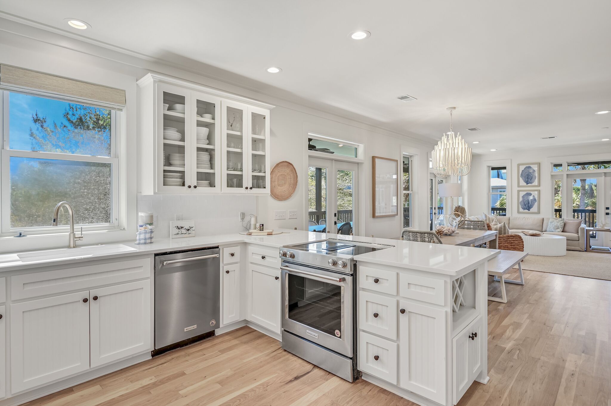 A modern kitchen with white cabinetry, stainless steel appliances, and a large island.