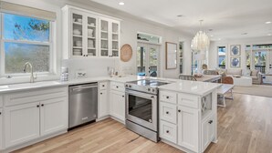 Una cocina moderna con armarios blancos, electrodomésticos de acero inoxidable y una isla grande.