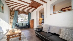 Relax in this inviting living room with a leather sofa, coffee table, and exposed wooden beams.