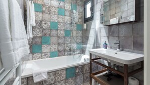 Une salle de bain avec une baignoire, un lavabo et une douche.