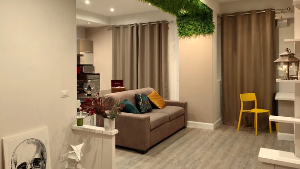 Ein modernes Wohnzimmer mit einer Couch, einem gelben Sessel und einem Essbereich.