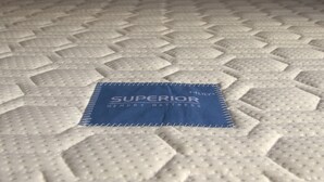 Eine Matratze mit Rillenmuster und einem blauen Etikett mit der Aufschrift "SUPERIOR MEMORY MATTRESS".