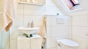 Ein modernes Badezimmer mit Oberlicht, Waschtisch und Toilette.