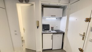 Een kleine keuken met een spoelbak, een koelkast en een vaatwasser.
