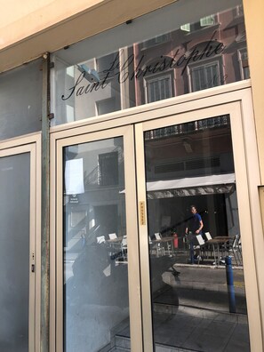 A storefront with a sign reading 'Saint Christophe' and a visible door with a sign above it.